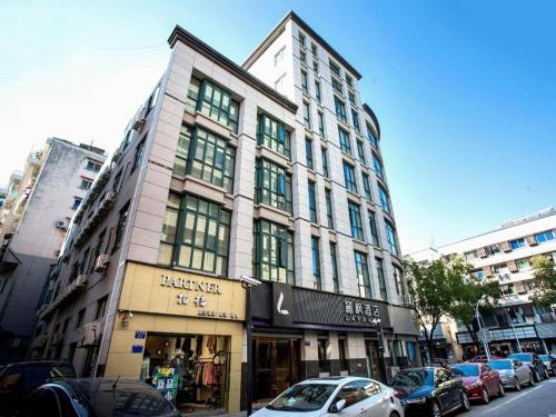 a tall building on a city street with cars parked at Lavande Hotel Jiande Xin'an River in Thousand Island Lake