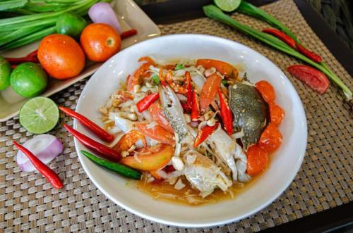 a plate of food with shrimp and vegetables on a table at Station 203 Hotel in Bangkok