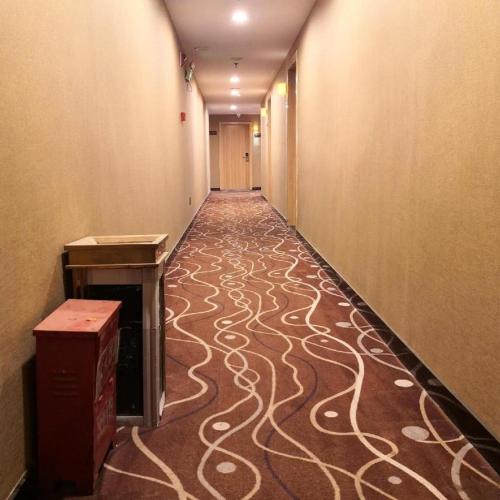 a hallway with a carpeted floor in a building at 7 Days Premium Hotel Ji'an Taihe Gongnongbing Avenue in Ji'an