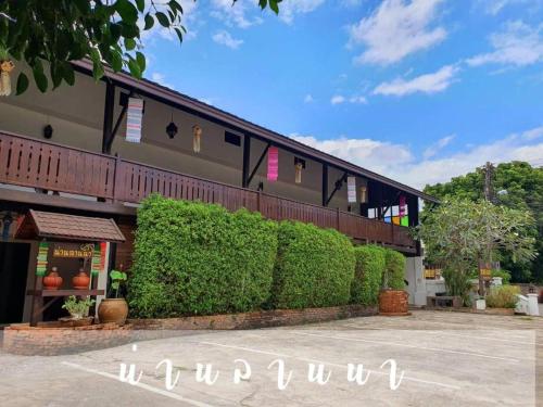 a building with green hedges in front of it at Nan Lanna Hotel in Nan