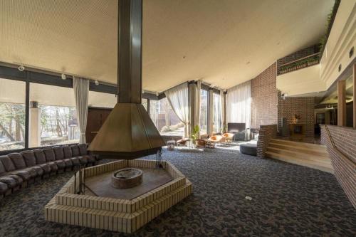 a living room with a fireplace in the middle at Fuji Shoei kaikan in Fuji