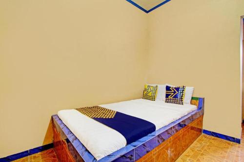 a small bed in a corner of a room at Hotel O Nakula Sadewa in Areman