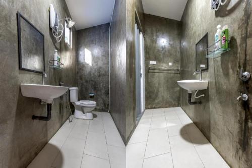 a bathroom with two sinks and a toilet and a shower at OYO 90149 Pua Family Semporna in Bulingisan