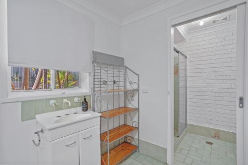 Un baño blanco con lavabo y ducha en Seaside Sanctuary I Spacious Getaway in Forster, en Forster