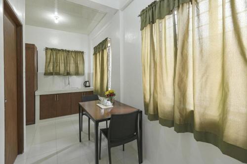 a dining room with a table and a kitchen at OYO 736 Jade Apartelle in Calamba
