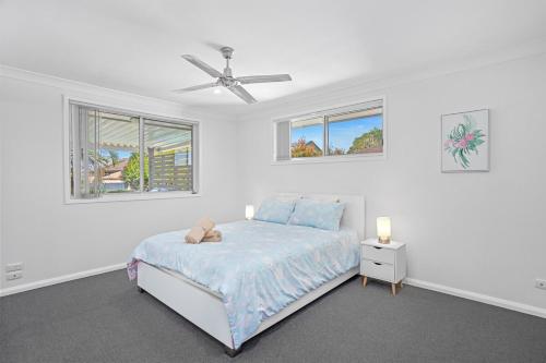 Un dormitorio blanco con una cama y dos ventanas. en Seaside Sanctuary I Spacious Getaway in Forster, en Forster