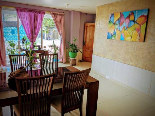 a dining room with a table and chairs and a painting at Me Quedo Aqui, Casa Cerca del Aeropuerto de Cartagena! in Cartagena de Indias