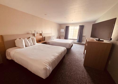 a hotel room with two beds and a flat screen tv at Wingate by Wyndham Anchorage Downtown - Ship Creek in Anchorage