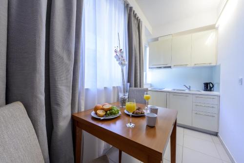 a kitchen with a table with a plate of fruit and drinks at Adriatic Deluxe Apartments in Dubrovnik