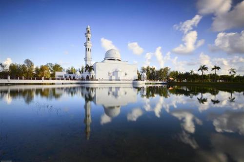 eine Moschee mit ihrem Spiegelbild in einem Wasserpool in der Unterkunft OYO 90471 Hotel Tepoh in Kampong Banggol Binjai