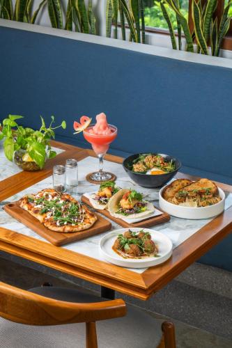 a table with four pizzas and a drink on it at Arpana Luxury Private Pool Villas in Jimbaran