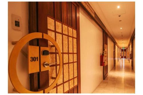a hallway with a door with a sign on it at Capital O 897 Takara Hotel And Events Place in Calamba