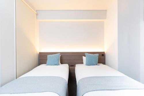 Postel nebo postele na pokoji v ubytování Living like Hotel 博多駅南