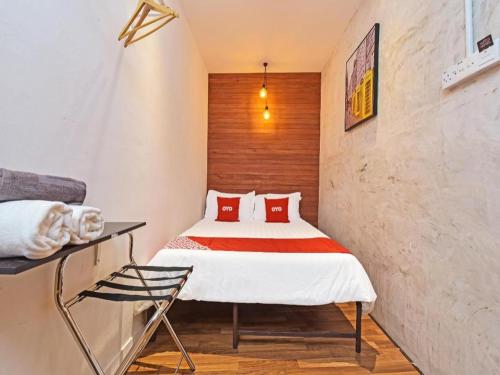 - une chambre avec un lit doté d'oreillers rouges dans l'établissement OYO 90662 The 1975 Hotel, à Kampong Bukit Ubi