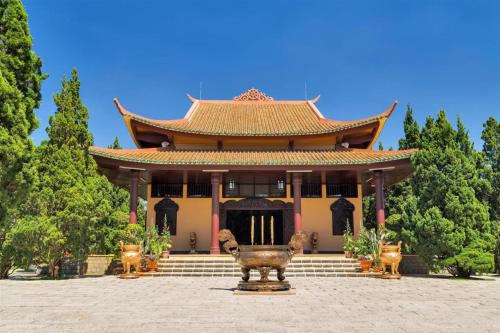 a large building with a statue in front of it at ADALY Hotel in Xuan An