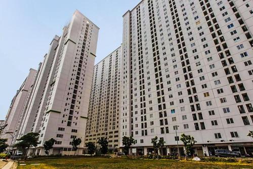 three large white buildings with trees in front of them at Capital O 91820 S&a Collection 2 in Jakarta