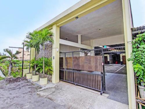 an entrance to a building with a gate and palm trees at OYO 91920 Pondok'ku Inn in Yogyakarta