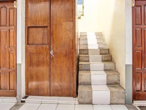 a stairway with two wooden doors and a set of stairs at OYO 91920 Pondok'ku Inn in Yogyakarta
