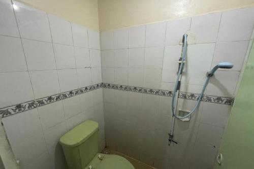 a bathroom with a green toilet and a shower at OYO 91920 Pondok'ku Inn in Yogyakarta