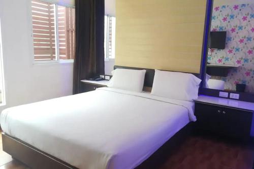 a large white bed in a bedroom with purple lighting at The Ring Khokmao Hotel in Ban Tha Sae