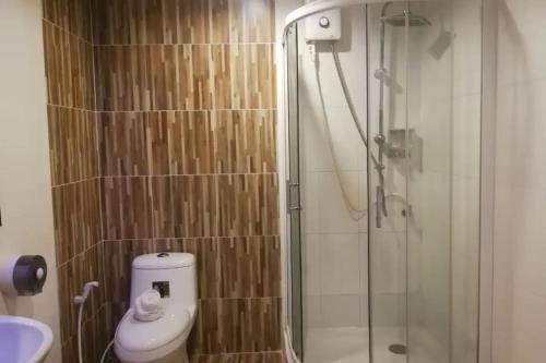 a bathroom with a shower with a toilet and a sink at The Ring Khokmao Hotel in Ban Tha Sae