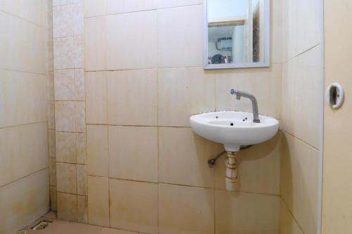 a bathroom with a sink and a mirror on the wall at Hotel O Benteng Kost in Jambi