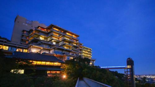 a large building on a hill at night at Ooedo Onsen Monogatari Minoh Kanko Hotel in Minoo
