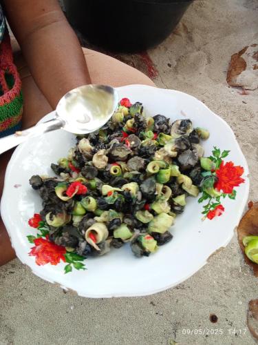 a bowl of food with a spoon on a plate at Raja Ampat Lovely homestay in Pulau Yefbie