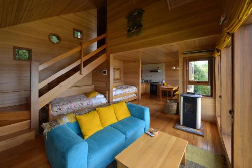 a living room with a blue couch and a staircase at Cabañas Alcamar in Castro