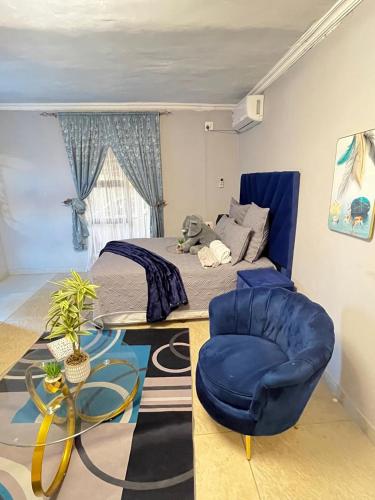 a bedroom with a bed and a blue chair at samama guesthouse in Groblersdal