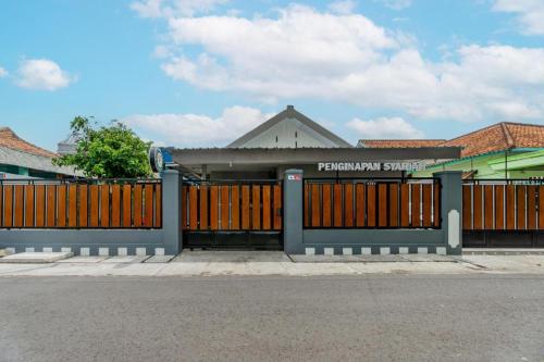a gate in front of aprimary school with a building at Homely Syariah in Kediri