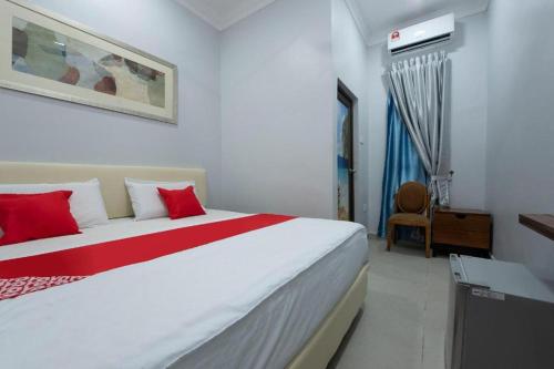 Un dormitorio con una gran cama blanca con almohadas rojas. en Sg Rengit City Resort 2, en Desaru