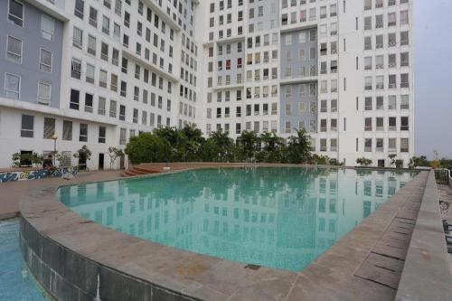 a large swimming pool in front of some buildings at Capital O 93594 Pelangi Urbano in Bekasi