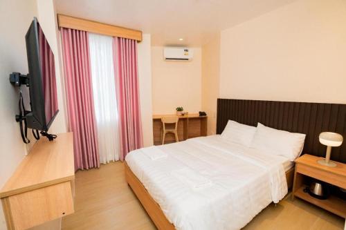 a hotel room with a bed and a flat screen tv at JVJ HOTEL in Batangas City