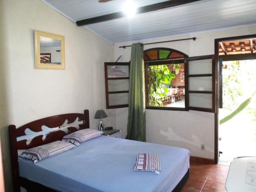 une chambre avec un lit bleu et une fenêtre dans l'établissement Suites BrisaMar, à Cabo Frio