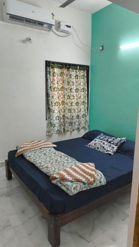 two beds in a room with a window at Shri Virajita - Budget 1 BHK Double Bed in Gokarna