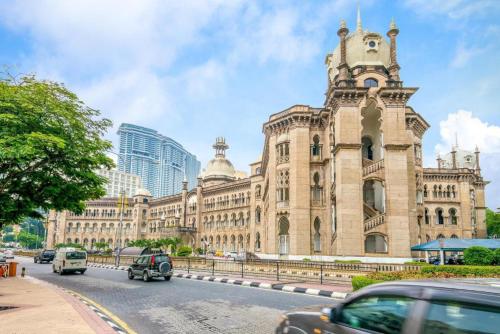 a large building with a clock tower on a street at Hotel O Bintang Holiday in Kuala Lumpur