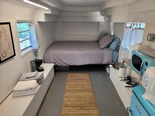 ジョシュア・ツリーにあるOne-of-kind Airstream for Your Desert Getaway!の小さなベッドルーム(トレーラー内のベッド付)
