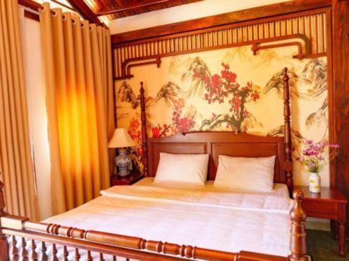 a bedroom with a bed with a painting on the wall at Jun's Home in Buon Ma Thuot