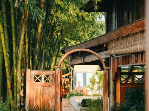an entrance to a house with a wooden gate and bamboo at Jun's Home in Buon Ma Thuot