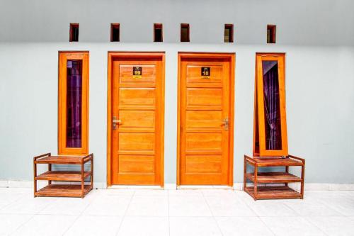 three wooden doors on the side of a building at Hotel O Ekslusive Double'n in Solo