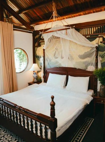 a bedroom with a large bed with a canopy at Jun's Home in Buon Ma Thuot
