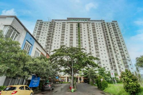 a large white building with cars parked in front of it at OYO 94150 Gateway Apartment Pasteur By Eldian in Bandung