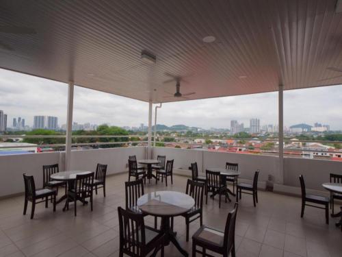 a restaurant with tables and chairs and a view of the city at Weiss Hotels Kepong Baru in Kuala Lumpur