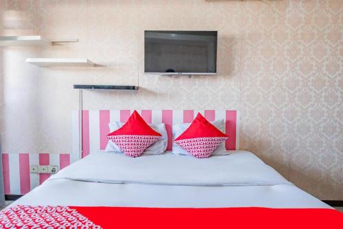 a bedroom with a bed with red and white pillows at OYO 94150 Gateway Apartment Pasteur By Eldian in Bandung