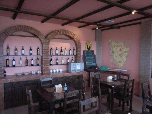 un ristorante con bar con bottiglie di vino appese al muro di Alfonso Hotel a Upli