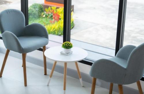 two chairs and a table in front of a window at Meesuk ChiangRai Hotel in Chiang Rai