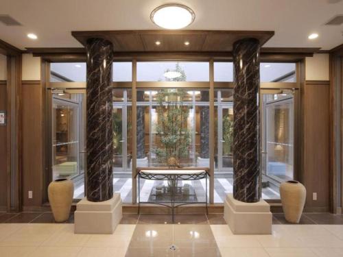 a lobby with two large columns in a building at Hotel Sunoak Kashiwanoha in Kashiwa