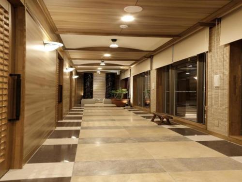 a hallway with a checkered floor in a building at Hotel Sunoak Kashiwanoha in Kashiwa