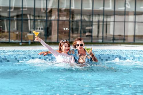 a man and a woman playing in a swimming pool at The Empyrean Cam Ranh Beach Resort in Cam Ranh